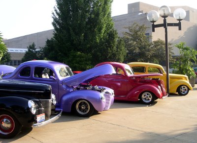 [Three brightly colored painted cars, each a different color.]